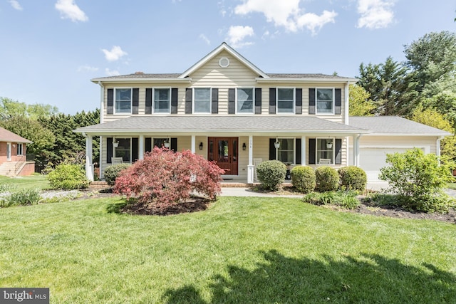 view of front of house with an attached garage, a front yard, and a porch