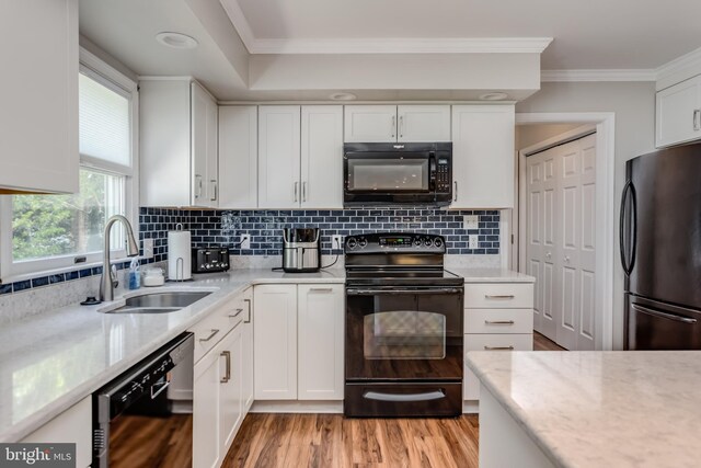 kitchen with white cabinets, a sink, and black appliances