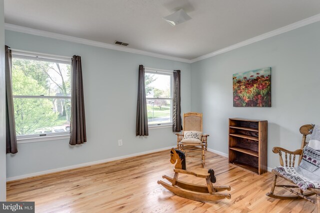 sitting room with baseboards, ornamental molding, wood finished floors, and visible vents