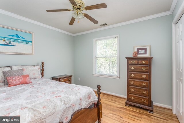 bedroom featuring visible vents, light wood-type flooring, baseboards, a closet, and ornamental molding