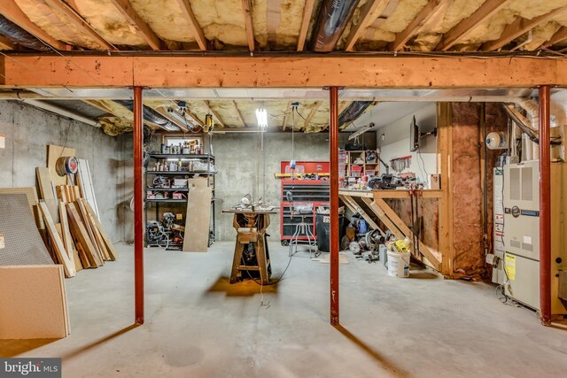 unfinished basement with heating unit and a workshop area