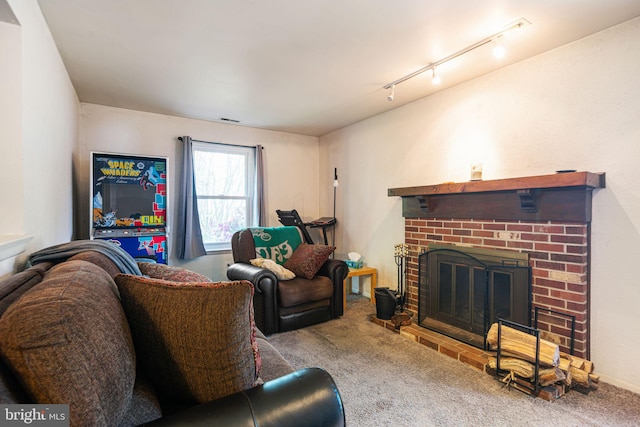 living room featuring carpet floors, rail lighting, and a fireplace