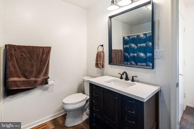 full bathroom with baseboards, vanity, toilet, and wood finished floors