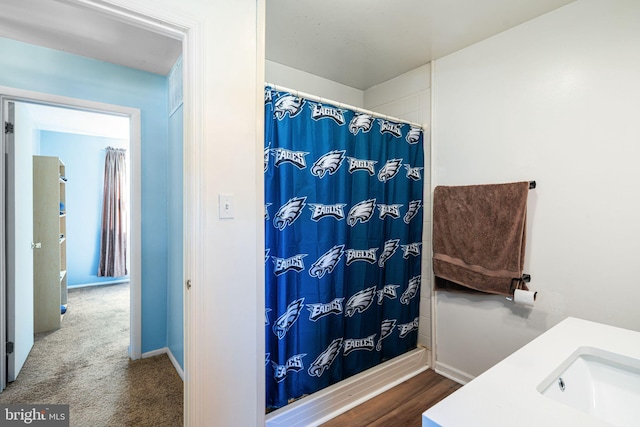 bathroom featuring a sink, a shower with curtain, and baseboards