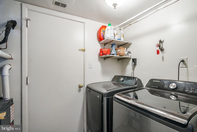 laundry room with laundry area, visible vents, and washing machine and dryer