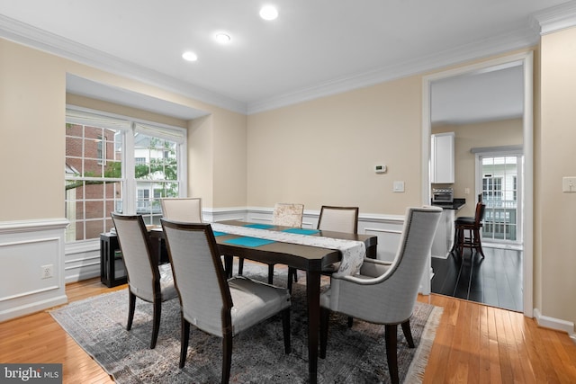 8878 Ashgrove House Ln, Vienna, VA 22182 - dining space with crown molding, a wealth of natural light, light wood-style flooring, and a wainscoted wall