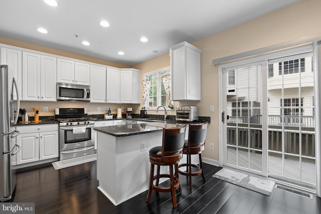 8878 Ashgrove House Ln, Vienna, VA 22182 - kitchen with white cabinets, stainless steel appliances, and dark wood-type flooring