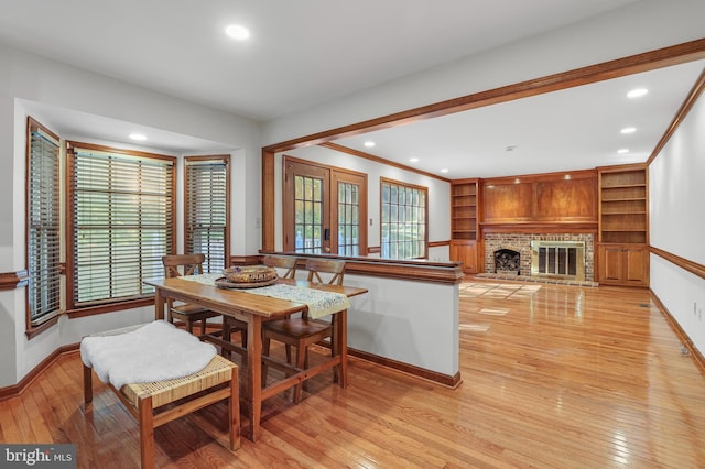dining space with baseboards, recessed lighting, light wood-style flooring, and a fireplace