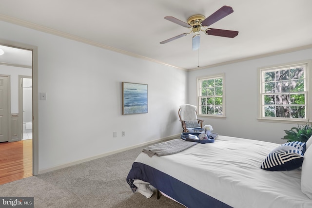 carpeted bedroom featuring crown molding, baseboards, and ceiling fan
