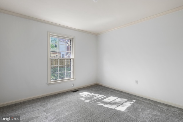 carpeted spare room featuring visible vents, ornamental molding, and baseboards