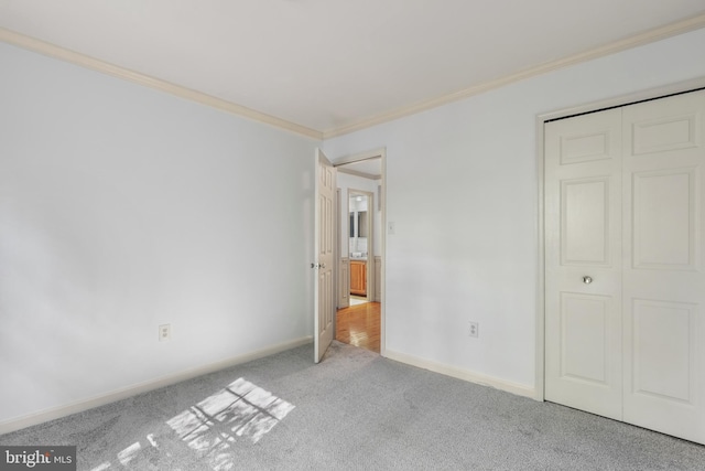 unfurnished bedroom with baseboards, ornamental molding, and carpet