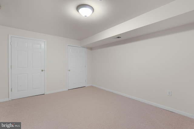 unfurnished bedroom with carpet flooring, baseboards, and visible vents