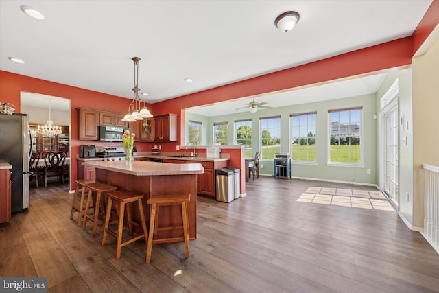 dining area featuring baseboards, ceiling fan with notable chandelier, recessed lighting, and wood finished floors