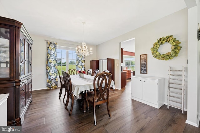 dining room featuring baseboards, dark wood finished floors, and a chandelier