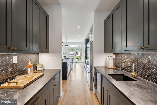 kitchen featuring backsplash, high quality fridge, and a sink