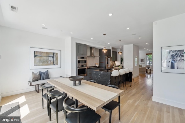 dining area with recessed lighting, baseboards, visible vents, and light wood-style flooring