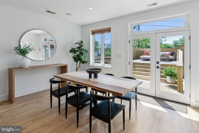 dining space featuring visible vents, light wood-style flooring, and french doors