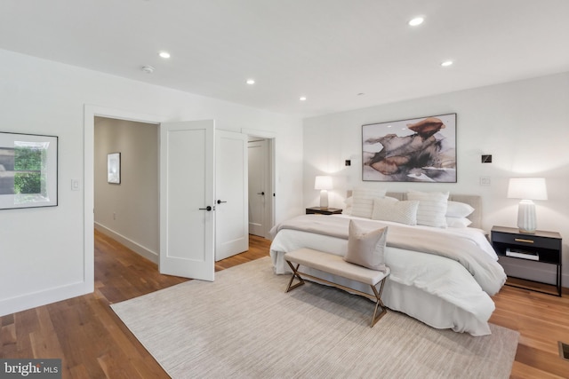 bedroom with recessed lighting, baseboards, and wood finished floors