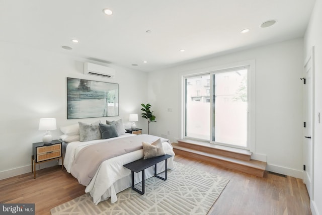 bedroom with visible vents, access to exterior, a wall mounted AC, light wood-style floors, and recessed lighting
