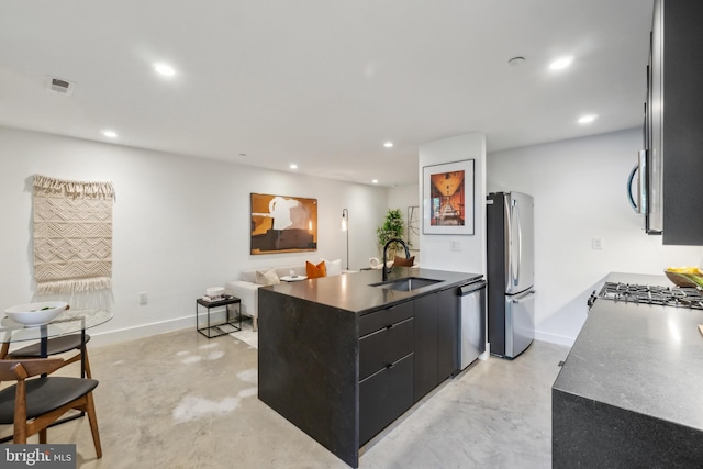 kitchen featuring dark cabinetry, a sink, concrete floors, and stainless steel appliances