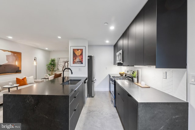 kitchen with finished concrete floors, recessed lighting, dark cabinetry, a sink, and appliances with stainless steel finishes