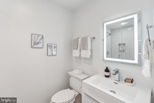 bathroom with vanity, a shower stall, and toilet