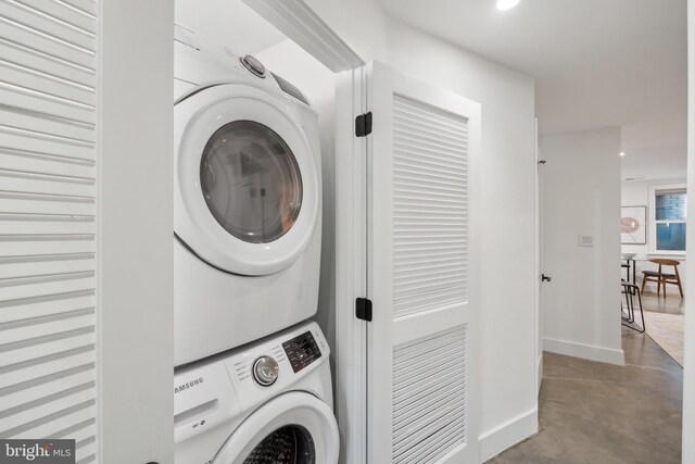 laundry room featuring stacked washing maching and dryer, baseboards, laundry area, and recessed lighting