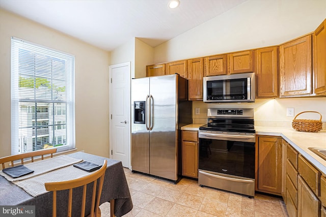 7524 Snowpea Ct Unit 9, Alexandria, VA 22306 - kitchen with brown cabinetry, light countertops, a healthy amount of sunlight, and stainless steel appliances