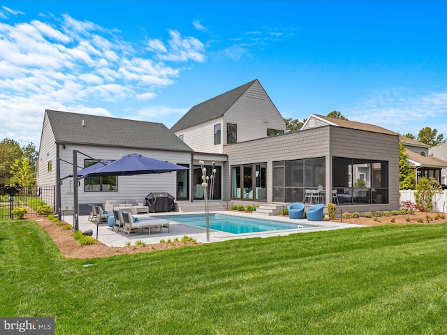 rear view of house featuring a yard, a patio, fence, and a sunroom