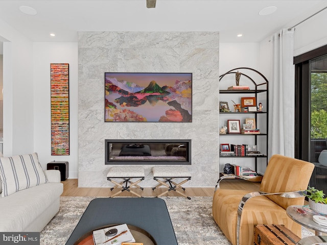 living room featuring recessed lighting, wood finished floors, and a fireplace