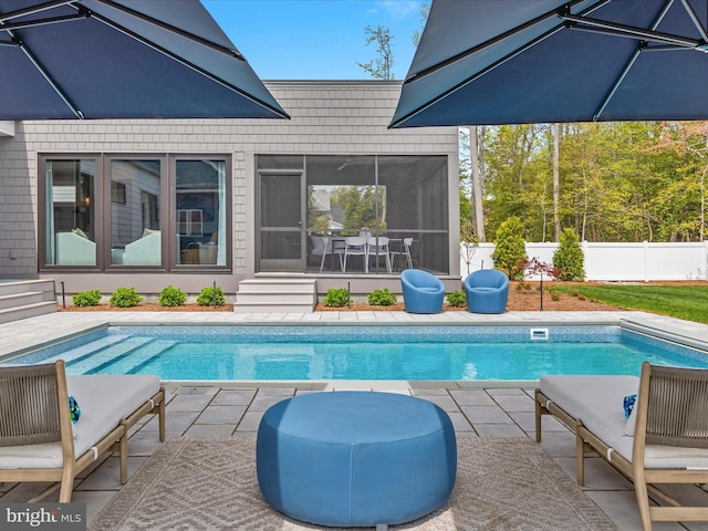 view of pool featuring a fenced in pool, fence, a patio, and a sunroom