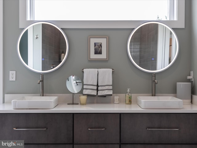 bathroom featuring double vanity, plenty of natural light, and a sink