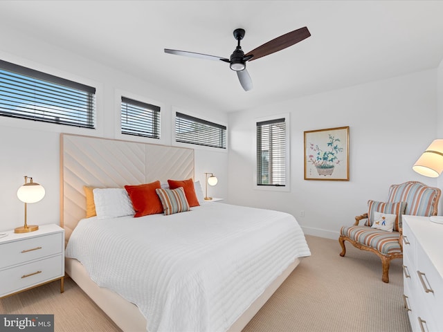 bedroom featuring baseboards, light carpet, and a ceiling fan