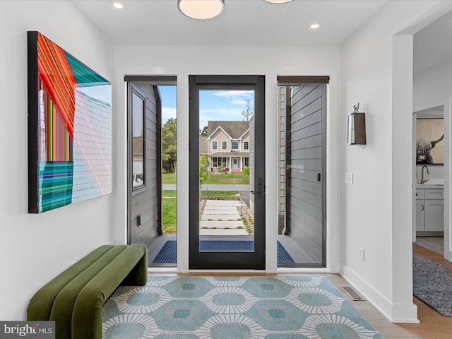 foyer entrance featuring recessed lighting, baseboards, visible vents, and light wood finished floors