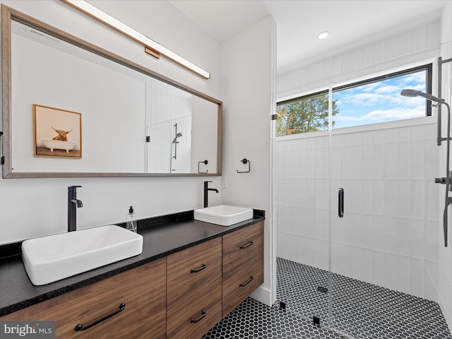 full bath with double vanity, a sink, recessed lighting, and a shower stall