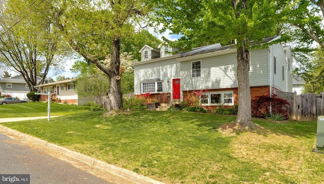 split foyer home with fence and a front yard