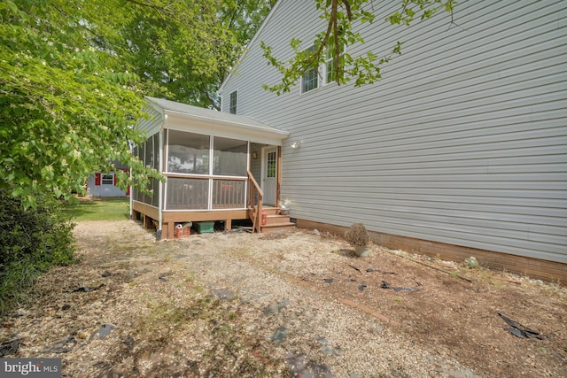 rear view of house featuring a sunroom