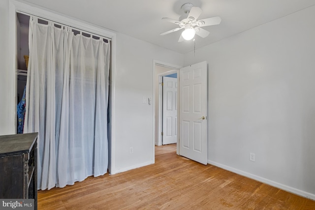 unfurnished bedroom with baseboards, light wood finished floors, ceiling fan, and a closet