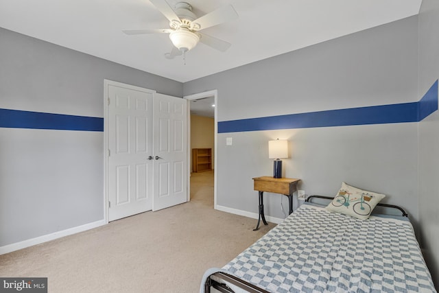 bedroom with baseboards, a ceiling fan, carpet, and a closet