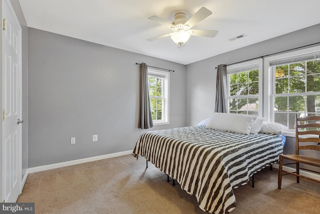 carpeted bedroom featuring baseboards, visible vents, and ceiling fan