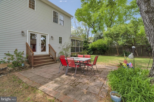 view of patio / terrace with a fenced backyard, french doors, a sunroom, entry steps, and outdoor dining space
