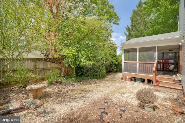 view of yard featuring a sunroom and fence