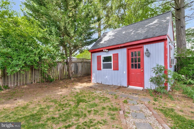 view of outdoor structure featuring a fenced backyard and an outbuilding