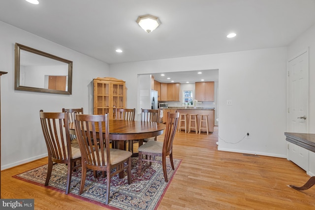 dining room featuring recessed lighting, baseboards, and light wood-type flooring