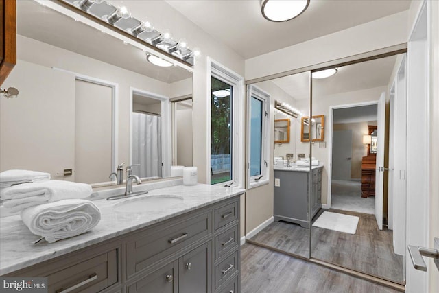 11801 Cherry Grove Dr, Gaithersburg, MD 20878 - bathroom featuring two vanities, a sink, and wood finished floors