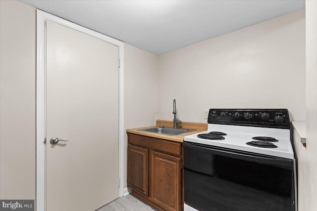 11801 Cherry Grove Dr, Gaithersburg, MD 20878 - kitchen with light countertops, electric range oven, light wood-style flooring, and a sink