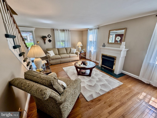 460 Burmont Rd, Drexel Hill, PA 19026 - living area with baseboards, a fireplace with flush hearth, wood finished floors, ornamental molding, and stairway