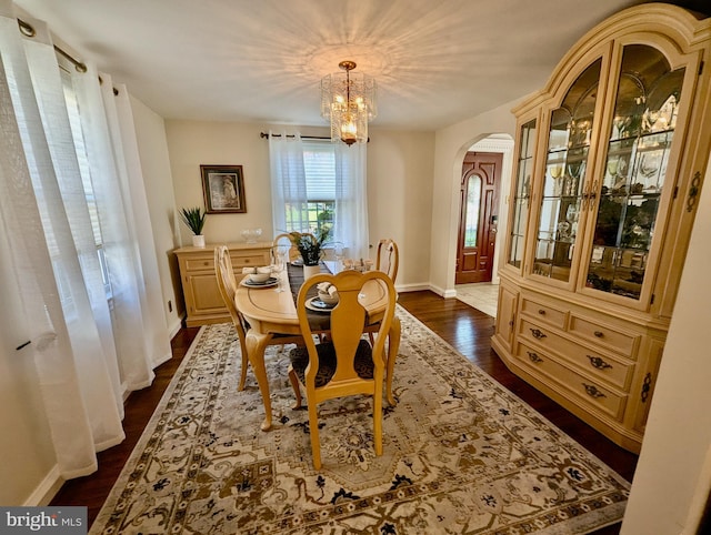 460 Burmont Rd, Drexel Hill, PA 19026 - dining area with baseboards, arched walkways, a notable chandelier, and dark wood-style floors