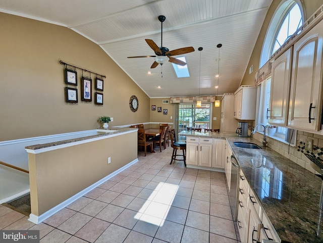 460 Burmont Rd, Drexel Hill, PA 19026 - kitchen with a sink, a peninsula, lofted ceiling with skylight, a ceiling fan, and dark stone countertops