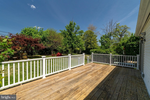 wooden terrace featuring a yard